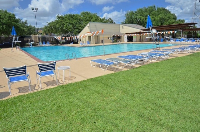 view of swimming pool with a yard and a patio area