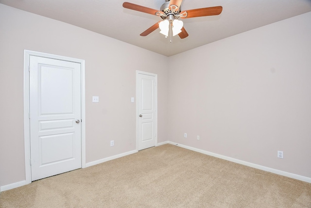 spare room featuring light colored carpet and ceiling fan