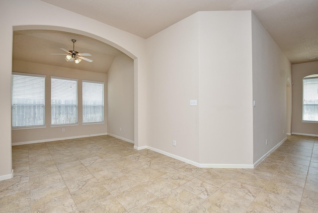 spare room featuring vaulted ceiling, a wealth of natural light, and ceiling fan