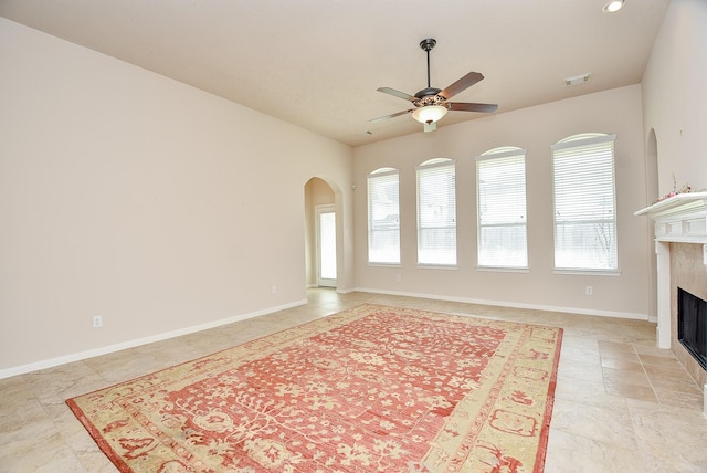 unfurnished living room with a fireplace and ceiling fan