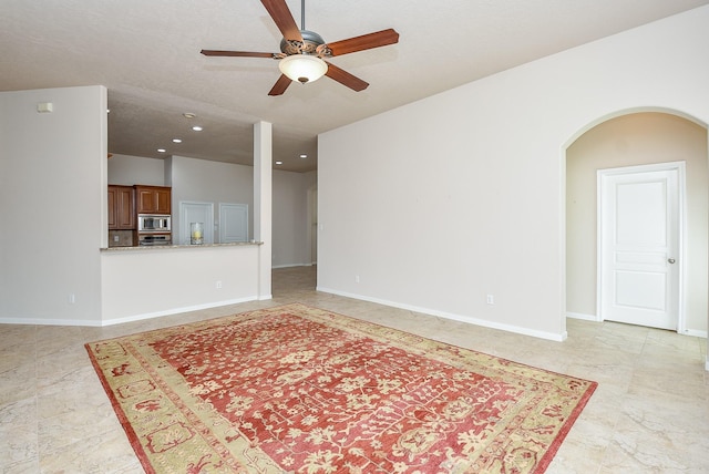 unfurnished living room featuring ceiling fan