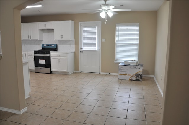 kitchen featuring stainless steel range with gas stovetop, light tile patterned floors, ceiling fan, decorative backsplash, and white cabinetry