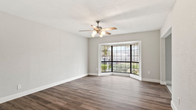 empty room featuring ceiling fan and dark hardwood / wood-style floors