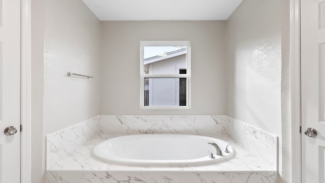 bathroom with a relaxing tiled tub