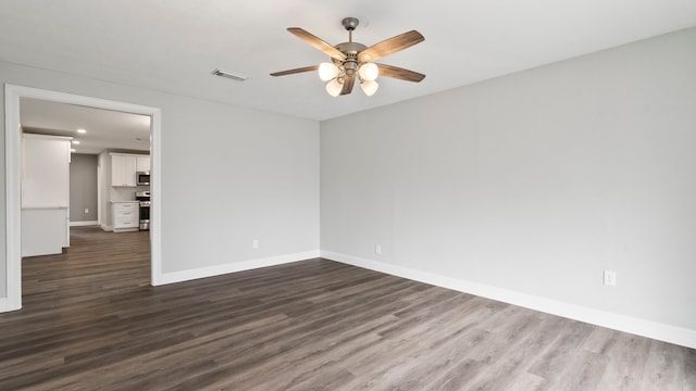 spare room featuring ceiling fan and dark hardwood / wood-style floors