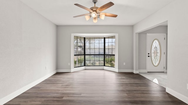 entrance foyer featuring dark hardwood / wood-style flooring, ceiling fan, and a wealth of natural light