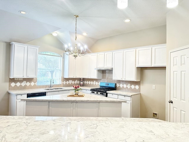 kitchen with sink, white cabinets, vaulted ceiling, and gas stove