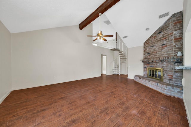 unfurnished living room with beam ceiling, ceiling fan, a brick fireplace, and dark hardwood / wood-style flooring