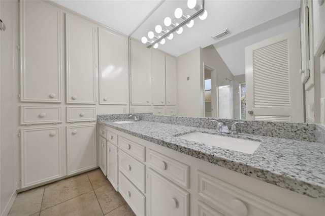 bathroom featuring vanity, vaulted ceiling, and tile patterned floors