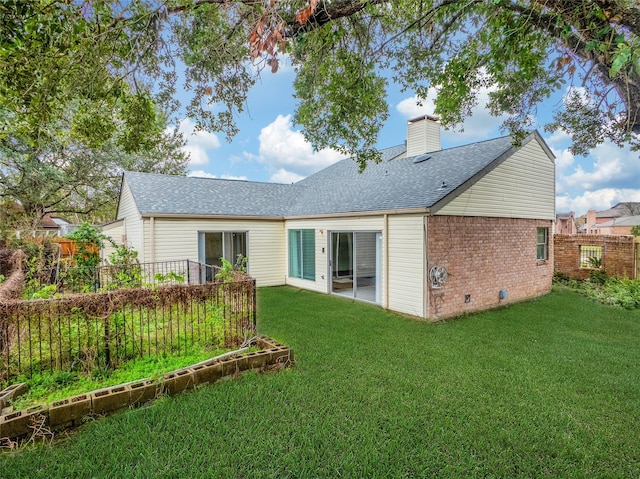 rear view of house featuring a yard