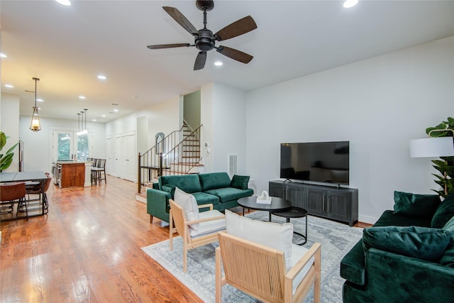 living room with wood-type flooring and ceiling fan