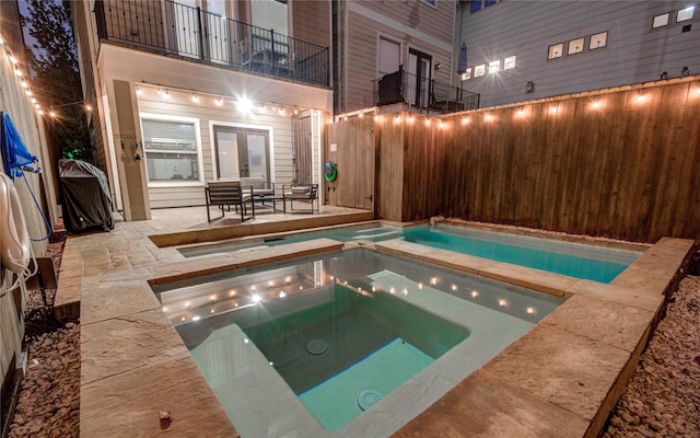 view of swimming pool featuring a patio area and an in ground hot tub