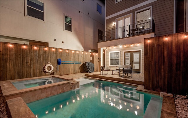 view of swimming pool featuring french doors, a patio area, and an in ground hot tub