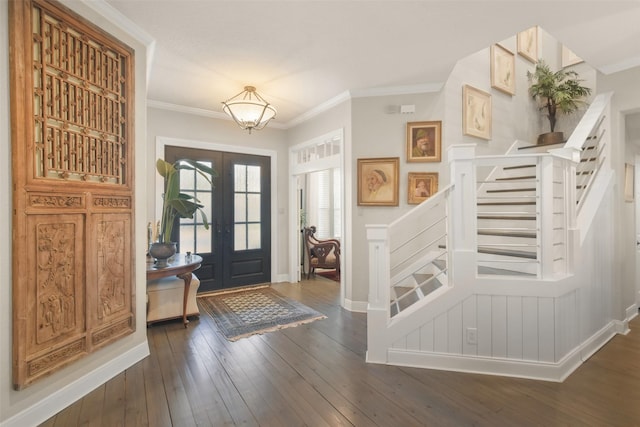 foyer featuring dark wood-type flooring, ornamental molding, and french doors