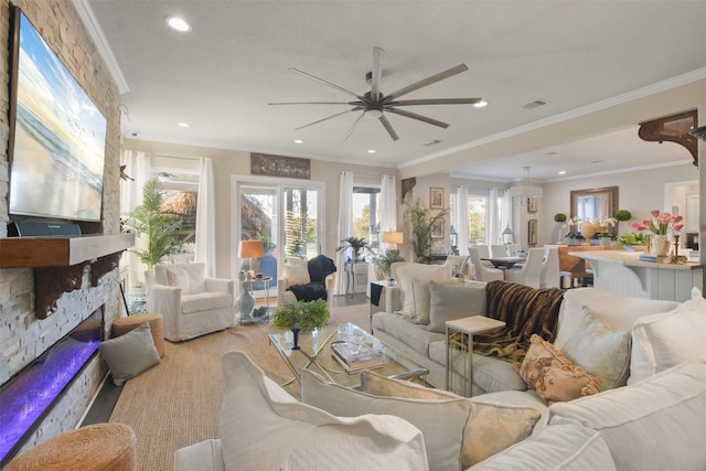 living room with ceiling fan, ornamental molding, a stone fireplace, and light wood-type flooring