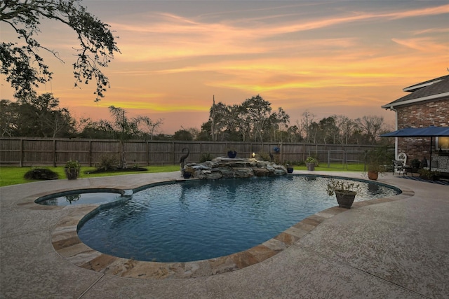 pool at dusk with a patio