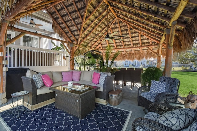 view of patio / terrace featuring ceiling fan, a gazebo, a wooden deck, and an outdoor hangout area