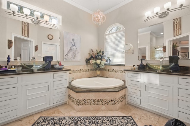 bathroom with ornamental molding, tile patterned flooring, tiled tub, and vanity