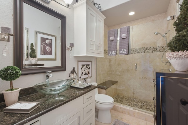 bathroom with a shower with shower door, vanity, and toilet