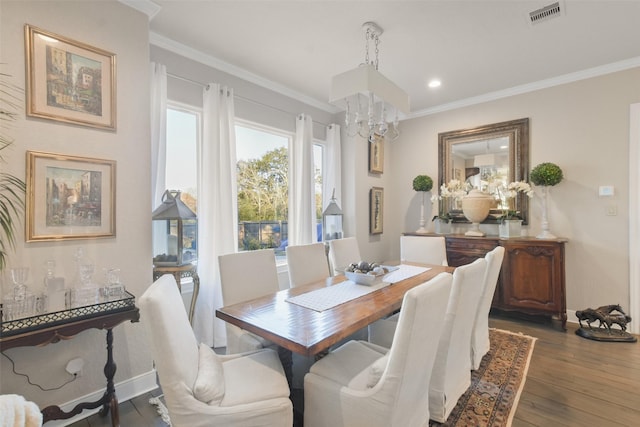 dining area featuring an inviting chandelier, dark hardwood / wood-style flooring, and crown molding