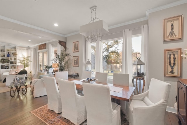 dining area with a chandelier, crown molding, and hardwood / wood-style floors