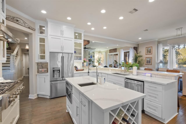 kitchen featuring stainless steel appliances, white cabinetry, a large island, and sink