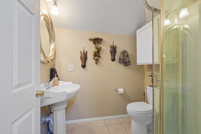 bathroom with toilet, tile patterned flooring, and sink