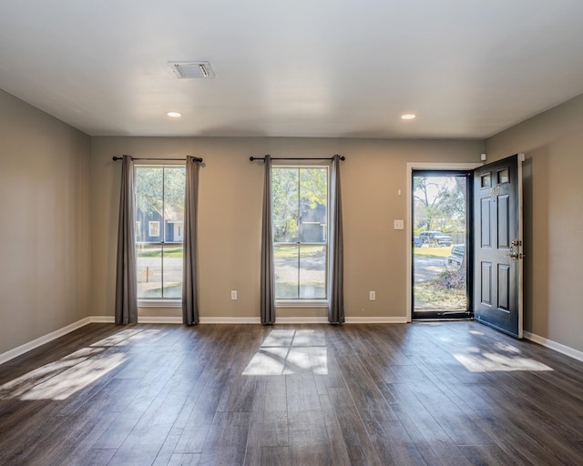 empty room featuring dark hardwood / wood-style flooring and plenty of natural light