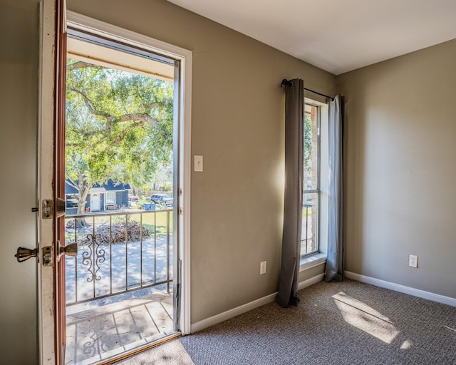 doorway to outside with a healthy amount of sunlight and carpet floors