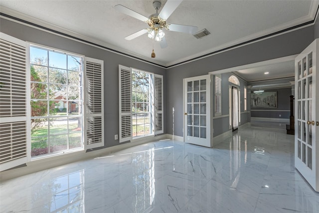 empty room with french doors, a textured ceiling, ornamental molding, and ceiling fan