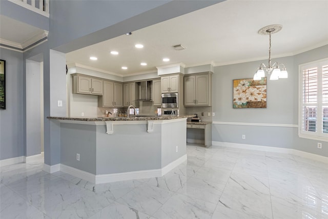 kitchen with ornamental molding, kitchen peninsula, gray cabinets, wall chimney range hood, and stainless steel microwave