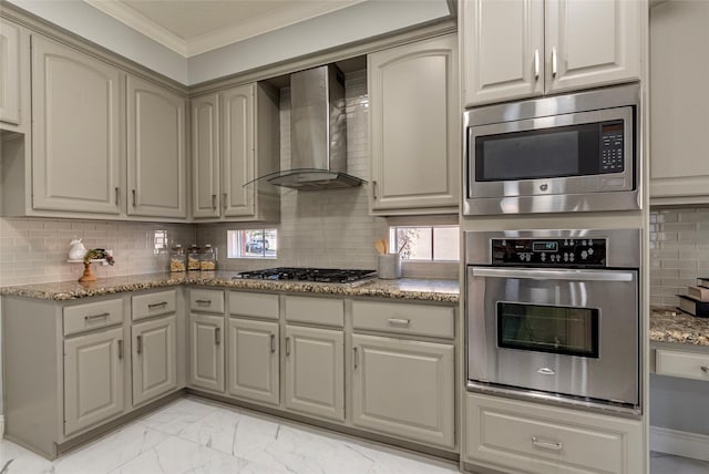 kitchen featuring stainless steel appliances, stone countertops, wall chimney range hood, and backsplash