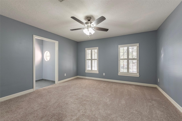 unfurnished room with ceiling fan, light carpet, and a textured ceiling