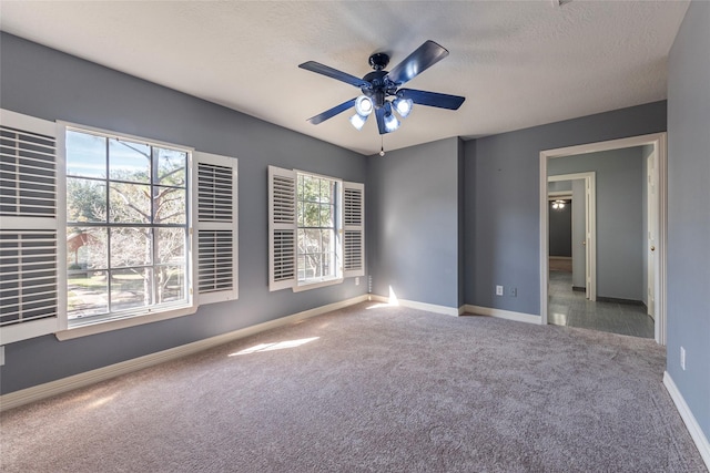 carpeted empty room featuring a textured ceiling and ceiling fan