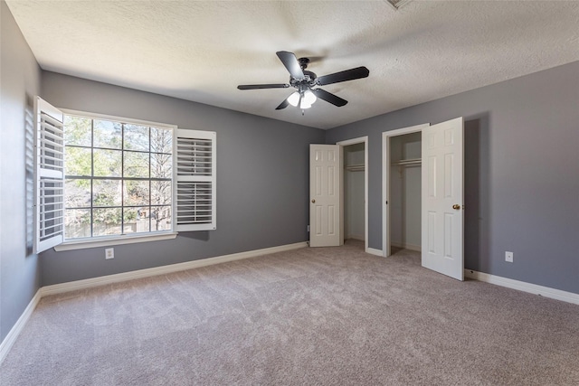 unfurnished bedroom featuring a textured ceiling, ceiling fan, and light carpet