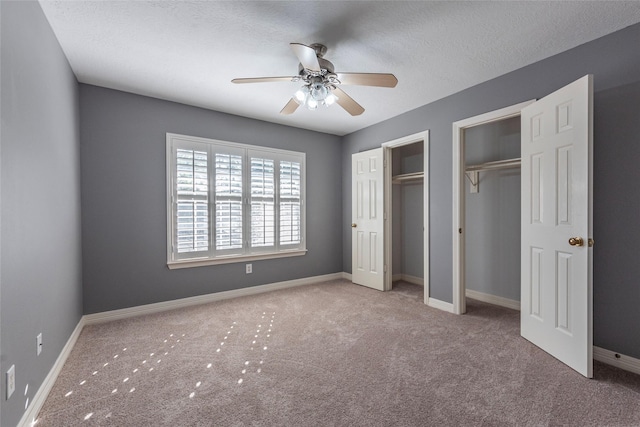 unfurnished bedroom featuring a textured ceiling, ceiling fan, and light colored carpet