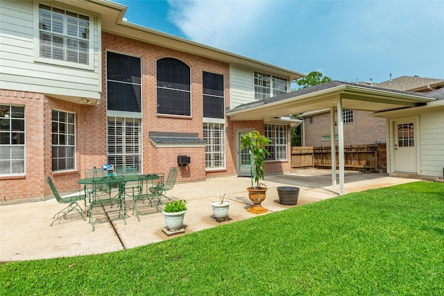 rear view of house with a lawn and a patio area