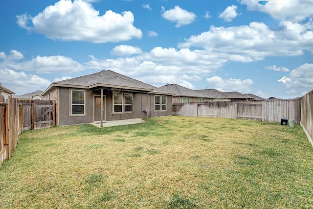 back of property with a yard and a patio area