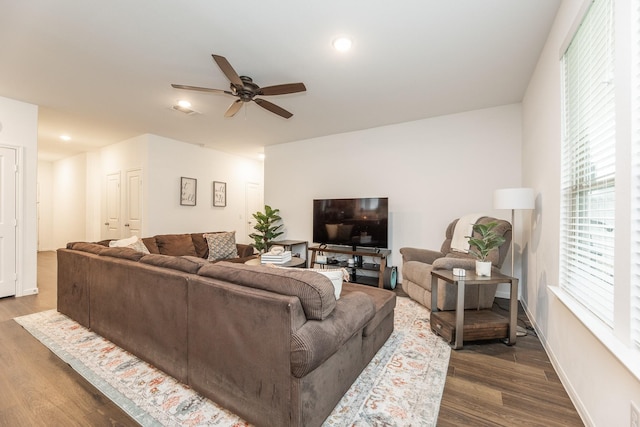 living room with ceiling fan and dark wood-type flooring