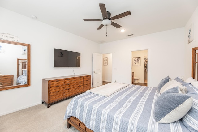 bedroom with ensuite bath, ceiling fan, and light colored carpet