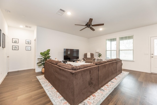 living room with dark hardwood / wood-style flooring and ceiling fan