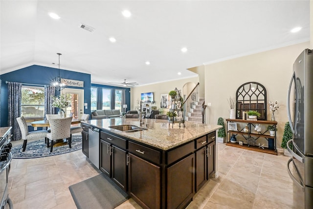 kitchen with stainless steel appliances, decorative light fixtures, vaulted ceiling, ceiling fan with notable chandelier, and a kitchen island with sink