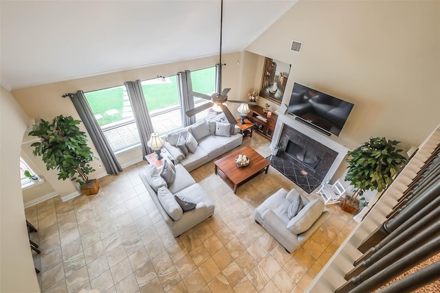 living room featuring lofted ceiling, a fireplace, and light tile patterned floors