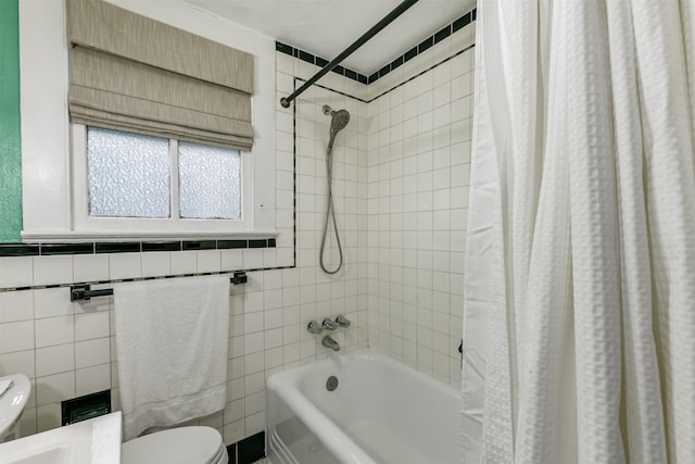 bathroom featuring toilet, shower / bath combo with shower curtain, and tile walls