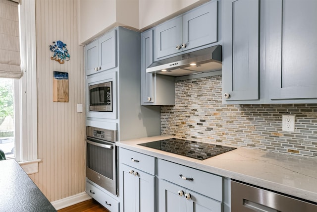 kitchen featuring light stone counters, appliances with stainless steel finishes, gray cabinetry, and tasteful backsplash