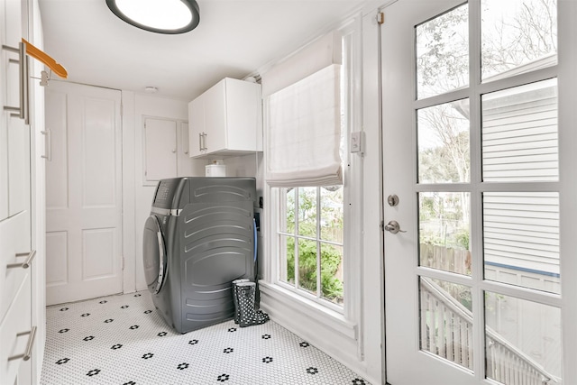 laundry room with washer / clothes dryer, light tile patterned flooring, and cabinets