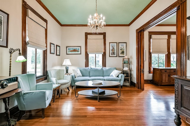 living room featuring ornamental molding, a notable chandelier, and hardwood / wood-style floors