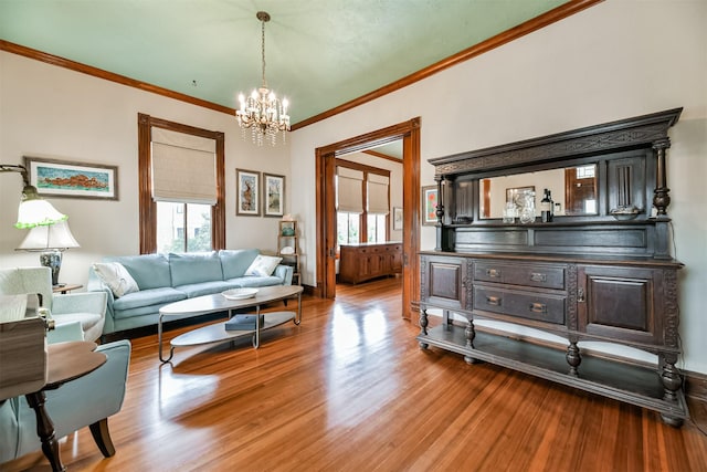 living room with hardwood / wood-style flooring, a notable chandelier, and ornamental molding