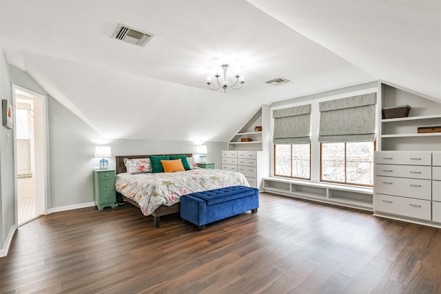 bedroom featuring a notable chandelier, dark hardwood / wood-style flooring, vaulted ceiling, and ensuite bath