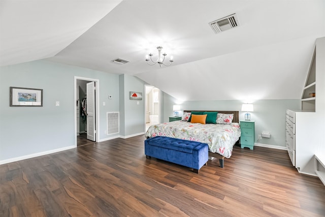 bedroom featuring dark hardwood / wood-style flooring, a spacious closet, an inviting chandelier, and vaulted ceiling